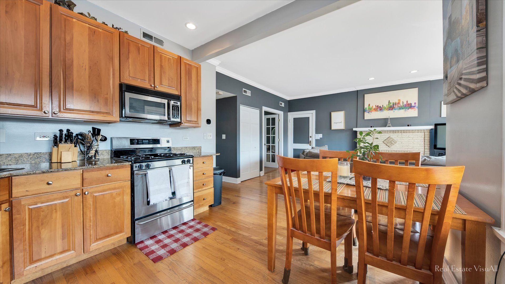 1340 West Irving Park Road, Unit 2 Chicago, IL 60613 - Photo 9 of 25 a large kitchen with stainless steel appliances granite countertop a refrigerator a stove a sink dishwasher and white cabinets with wooden floor