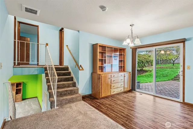 a view of a room with wooden floor and a kitchen