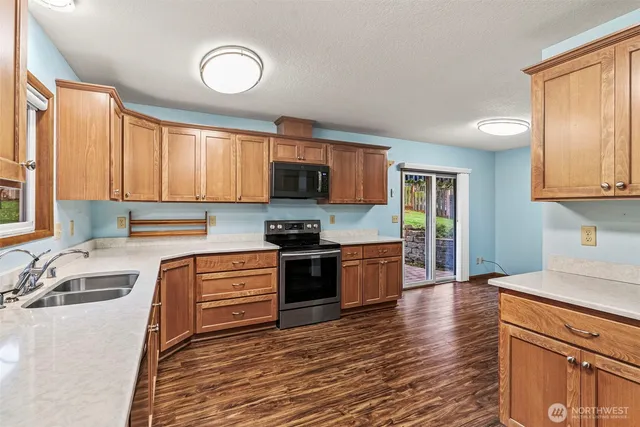 a kitchen with stainless steel appliances granite countertop a sink and wooden cabinets