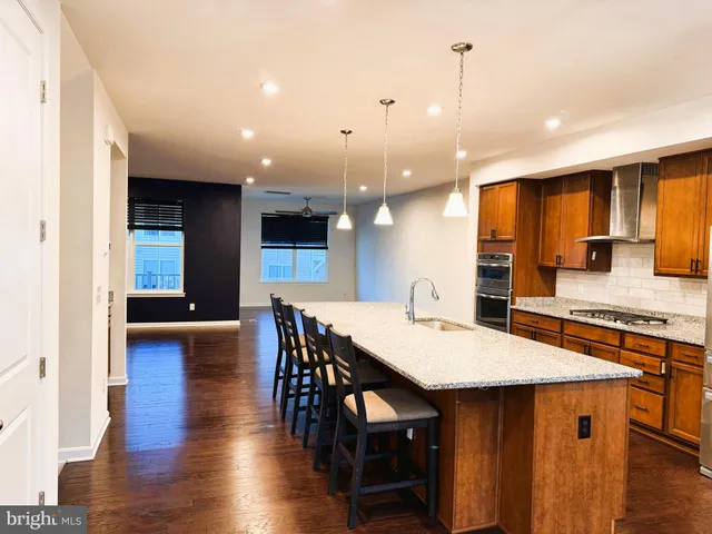 a kitchen with stainless steel appliances kitchen island granite countertop a kitchen island a stove a table and chairs