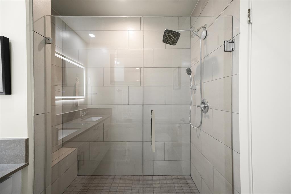 3922 Gilbert Avenue, Unit 214 Dallas, TX 75219 - Photo 14 of 27 Glass-enclosed shower featuring a square rainfall shower head and a handheld spray