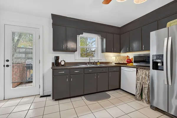 a kitchen with stainless steel appliances granite countertop a refrigerator and a stove top oven