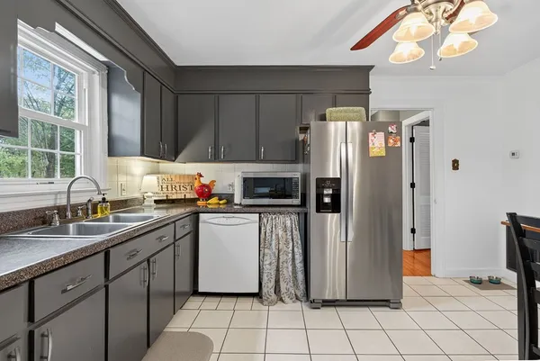 a kitchen with stainless steel appliances a refrigerator sink and microwave