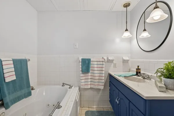 a bathroom with a sink vanity tub and a mirror