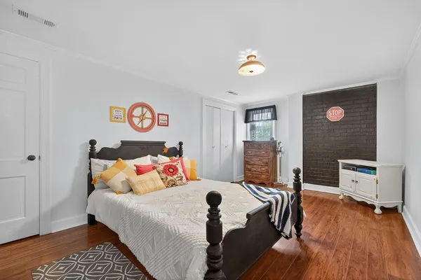 a bedroom with a bed and a table with wooden floor