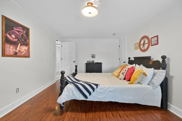 a bedroom with a bed and painting on the wall