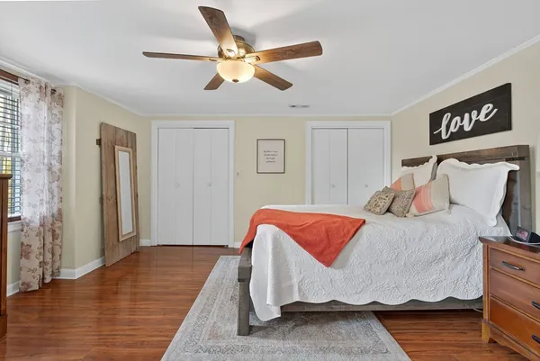 a bedroom with a bed and wooden floor