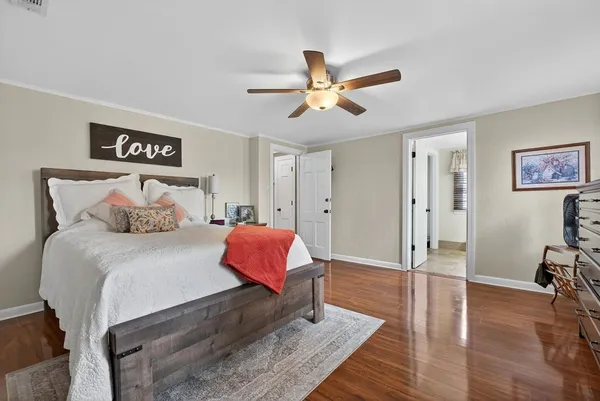a spacious bedroom with a bed and wooden floor