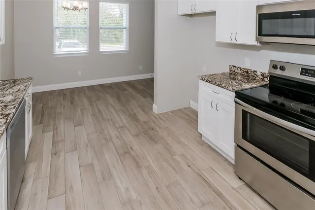 a kitchen with wooden floors and appliances