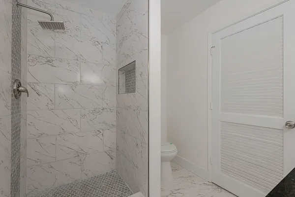 a bathroom with a granite countertop sink a toilet and bathtub