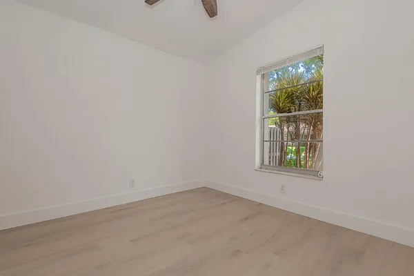 an empty room with closet and a chandelier fan