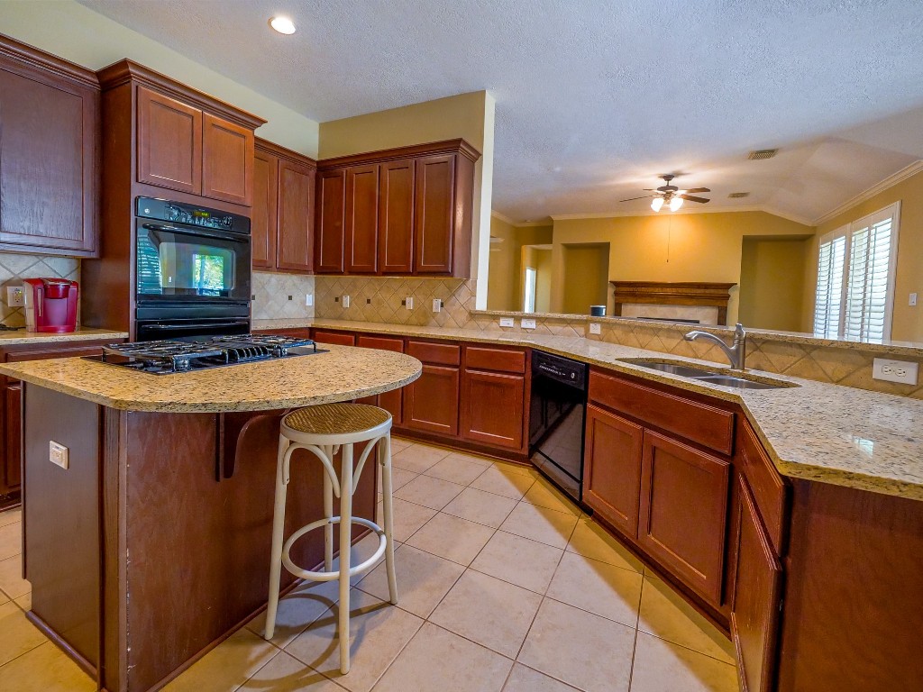 26173 Crown Ranch Boulevard Montgomery, TX 77316 - Photo 26 of 37 a kitchen with stainless steel appliances granite countertop a sink a stove counter space and cabinets