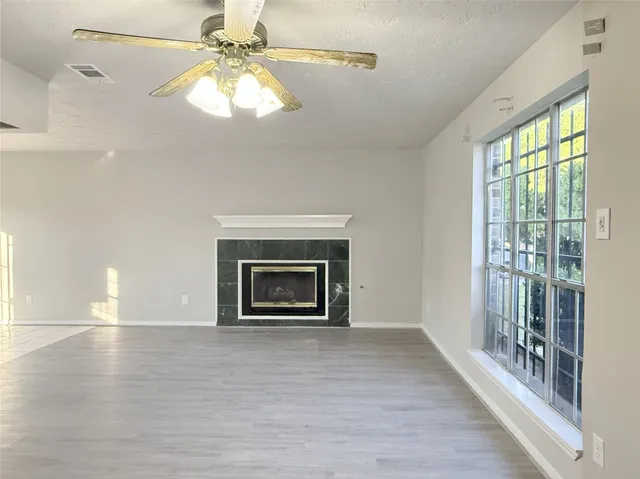 an empty room with windows and fireplace