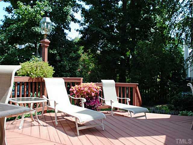 11213 North Radner Way Raleigh, NC 27613 - Photo 17 of 18 a view of a patio with table and chairs a barbeque and potted plants and large trees