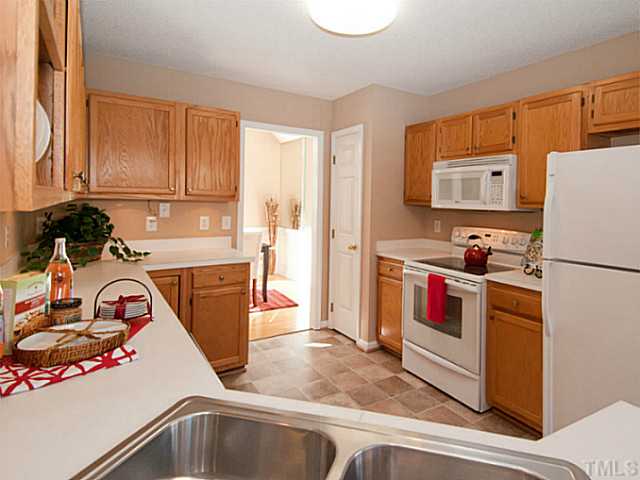 11213 North Radner Way Raleigh, NC 27613 - Photo 7 of 18 a kitchen with a refrigerator and a stove top oven