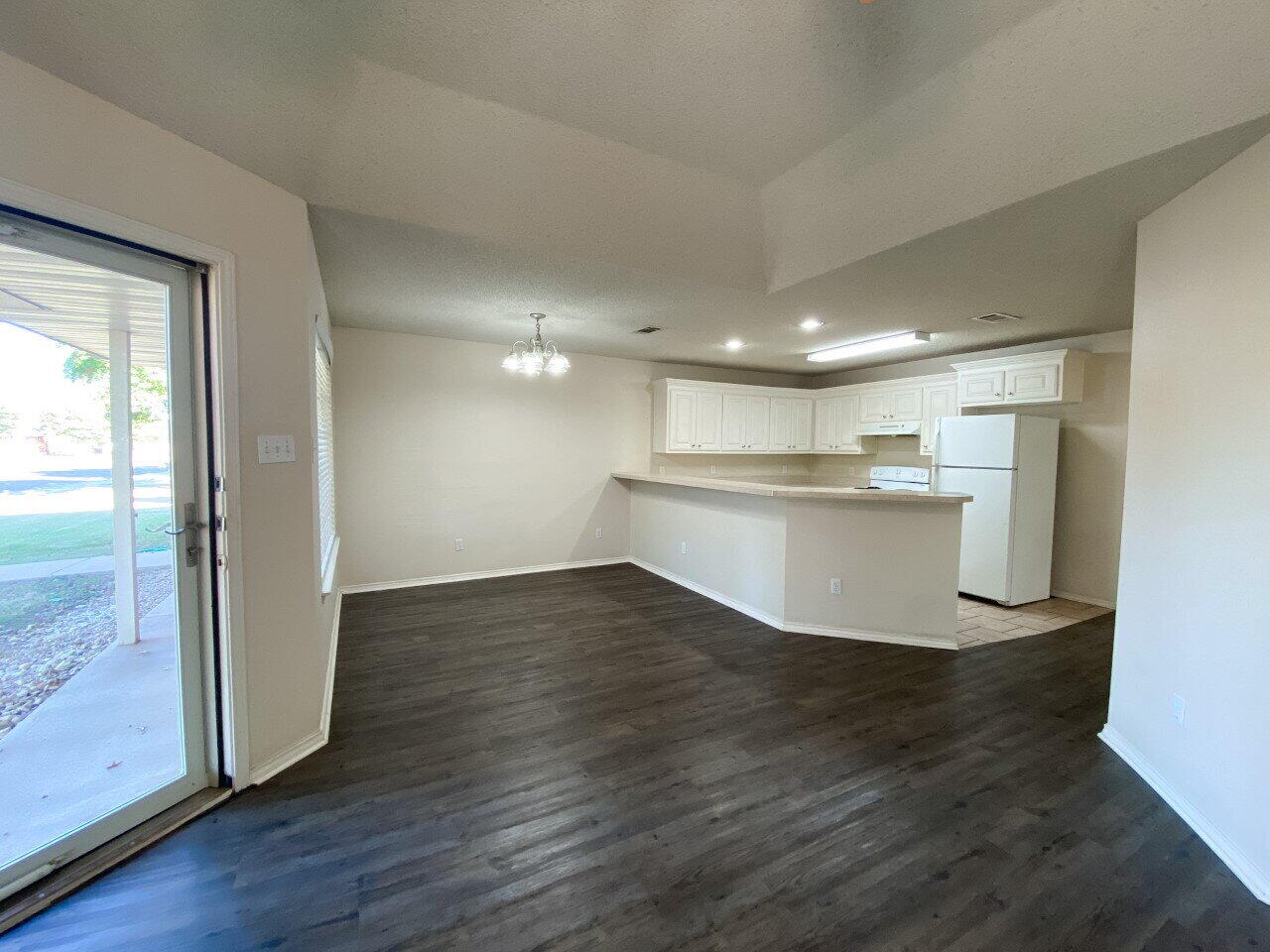 3209 110th Street, Unit B Lubbock, TX 79423 - Photo 2 of 7 a view of a kitchen with wooden floor and a window