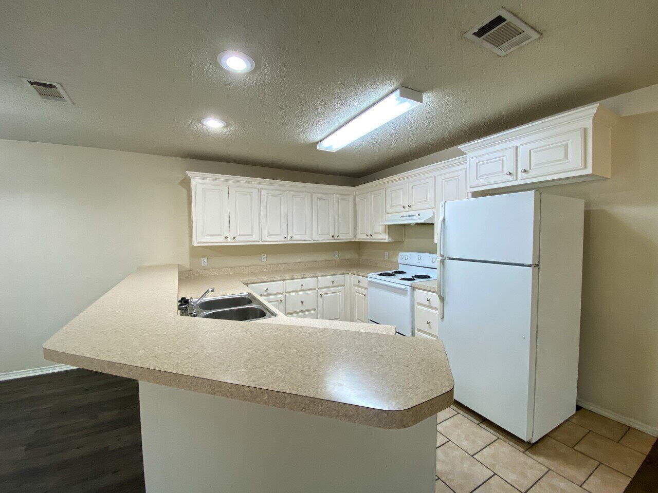 3209 110th Street, Unit B Lubbock, TX 79423 - Photo 4 of 7 a kitchen with a refrigerator a sink and a stove