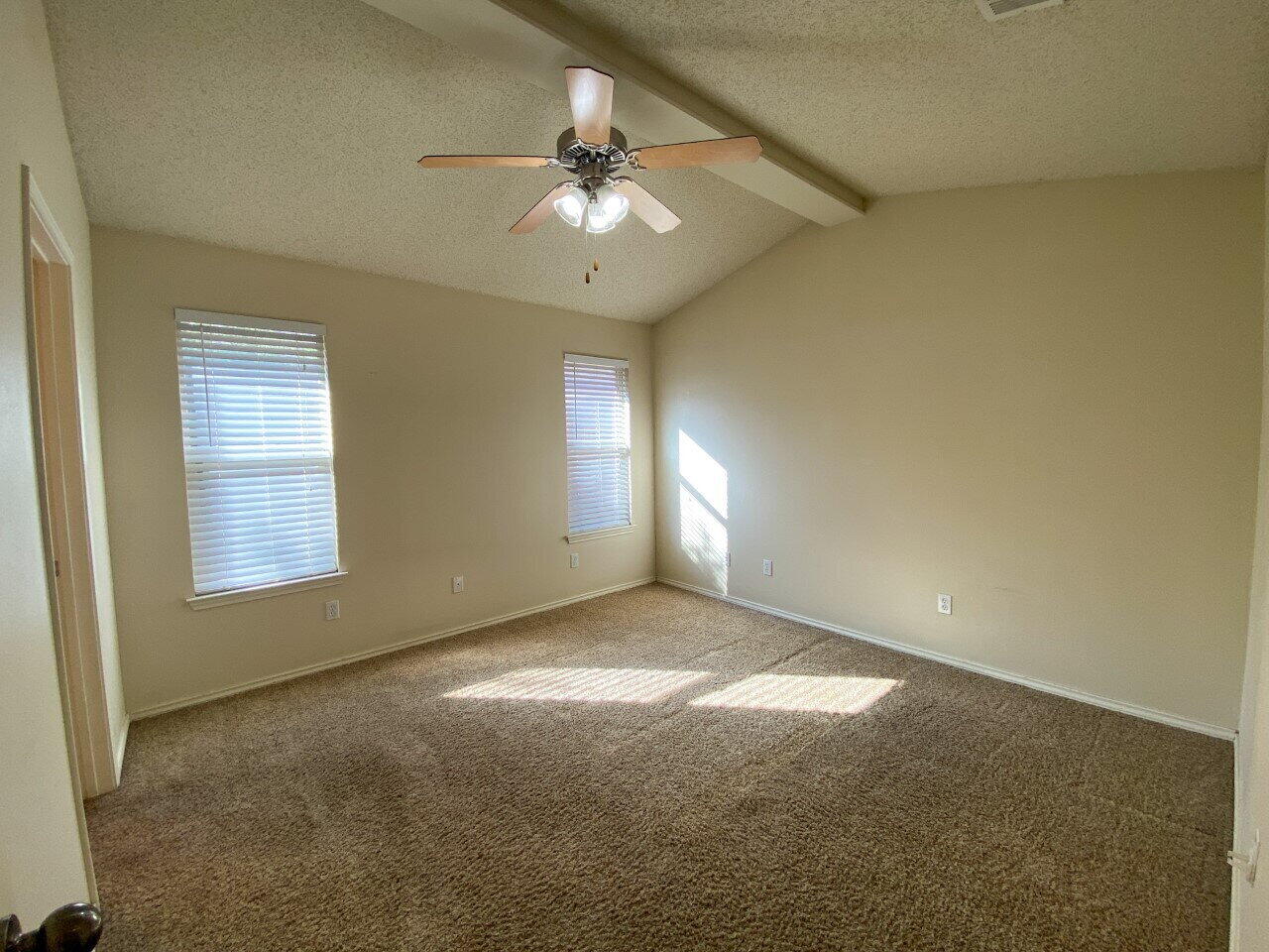 3209 110th Street, Unit B Lubbock, TX 79423 - Photo 5 of 7 an empty room with windows and chandelier fan