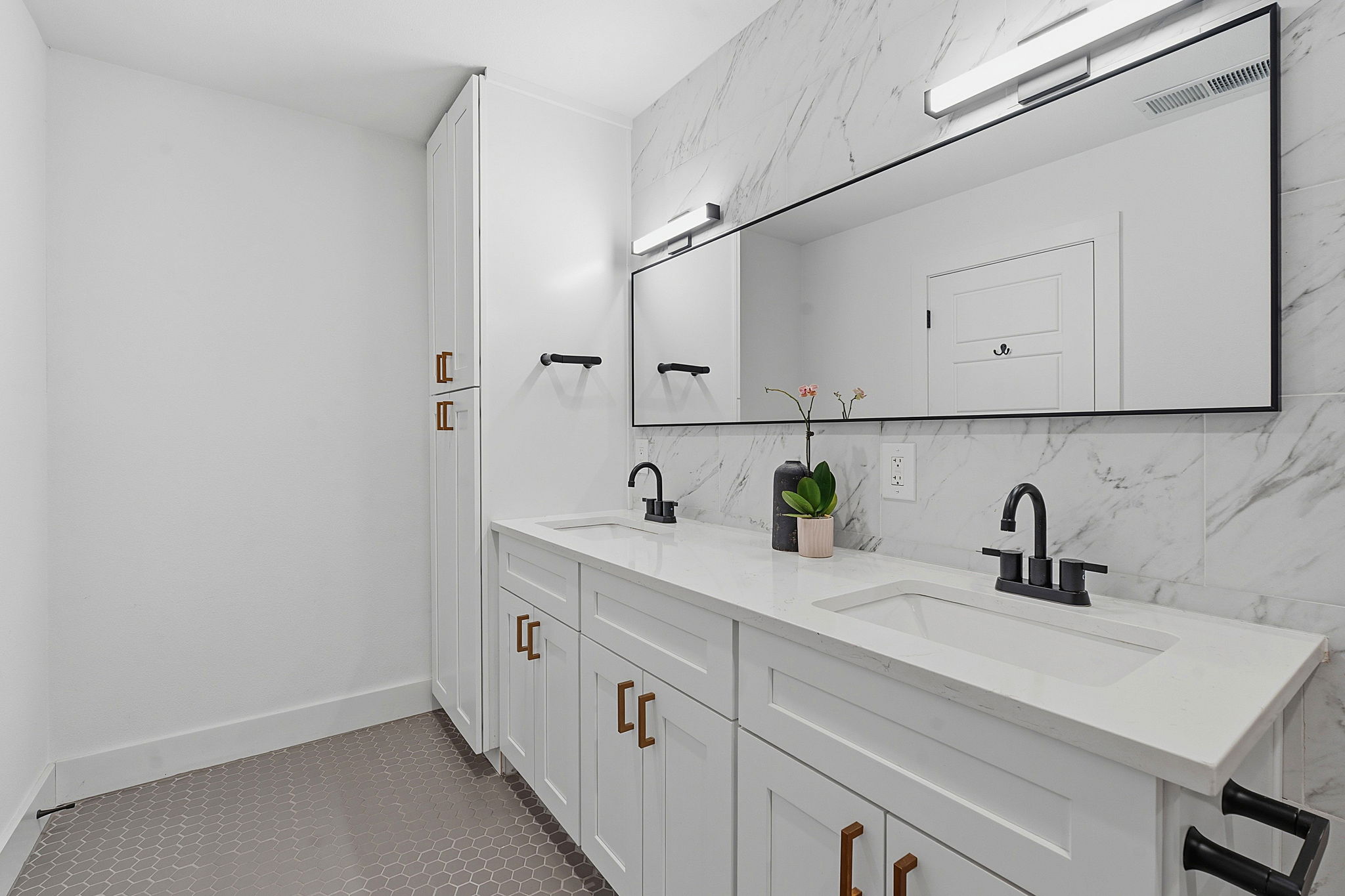 4403 Elmsgrove Drive Austin, TX 78721 - Photo 36 of 38 Dual vanity with bright white countertops, sleek black fixtures, and floor-to-ceiling storage.