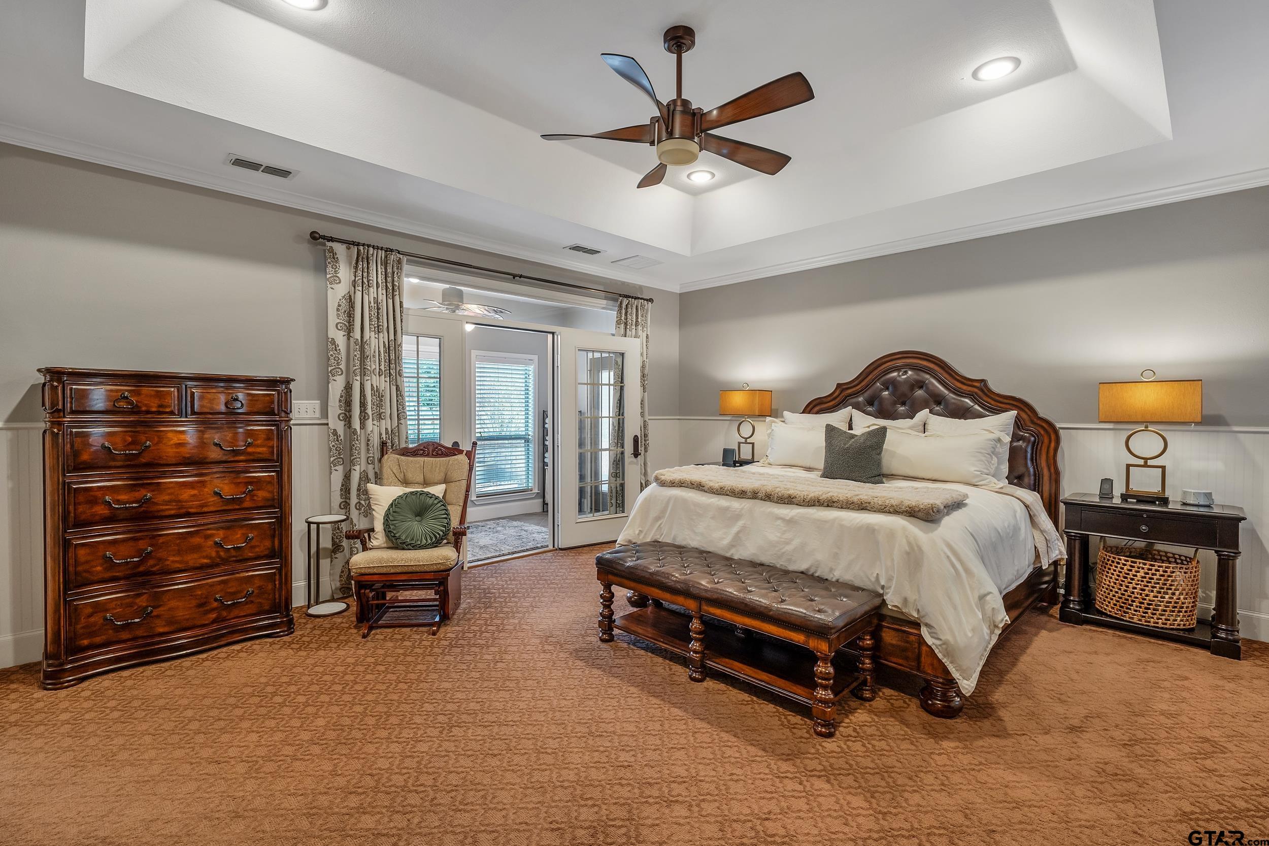 7752 Lamp Post Cove Tyler, TX 75703 - Photo 16 of 41 a spacious bedroom with a bed a couch and a chandelier