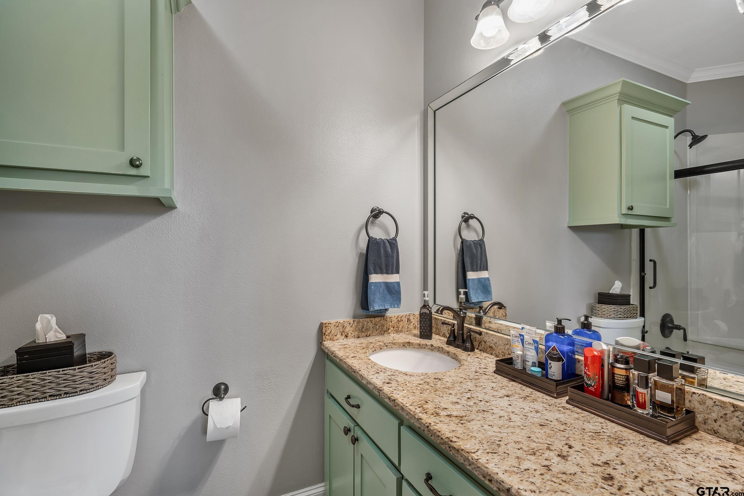 7752 Lamp Post Cove Tyler, TX 75703 - Photo 30 of 41 a bathroom with a granite countertop sink a toilet and a mirror