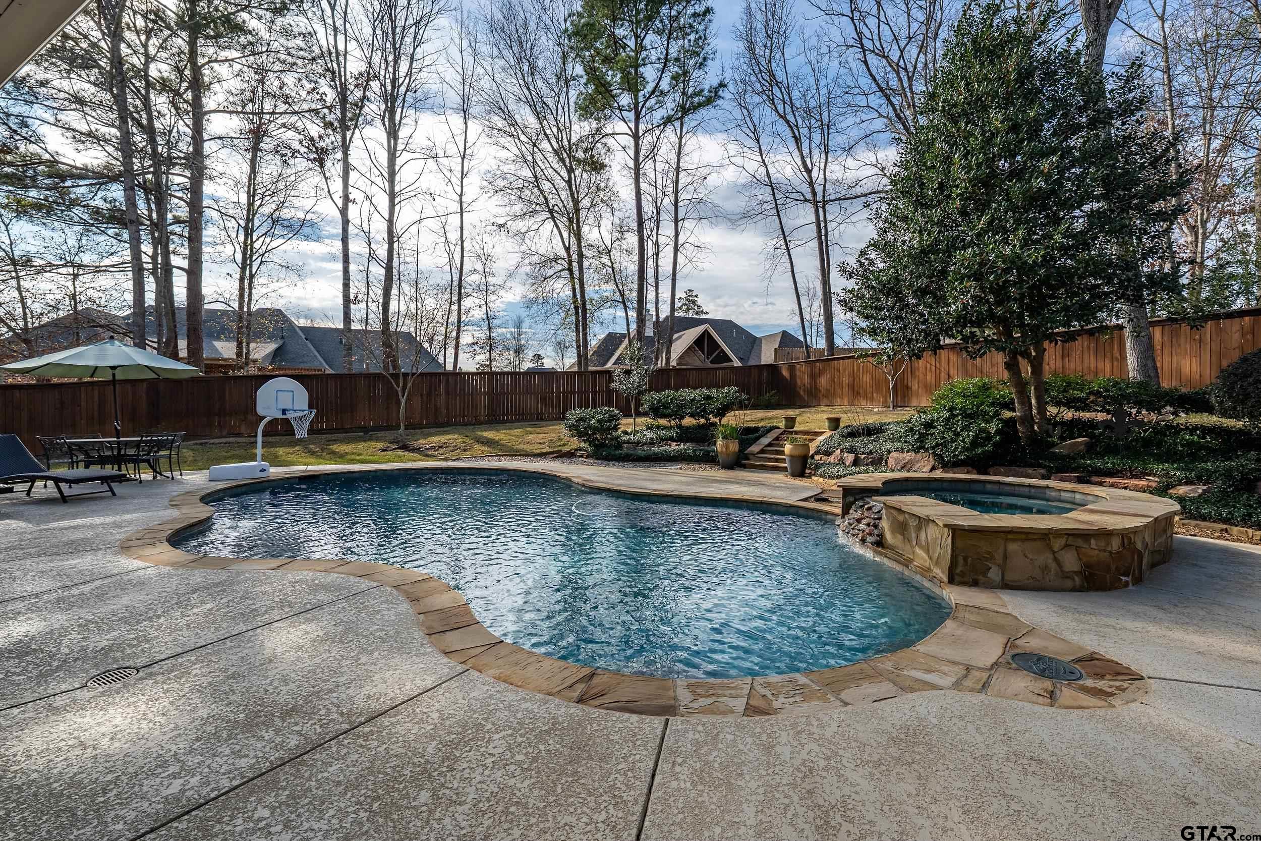 7752 Lamp Post Cove Tyler, TX 75703 - Photo 33 of 41 a view of a swimming pool with lawn chairs under an umbrella