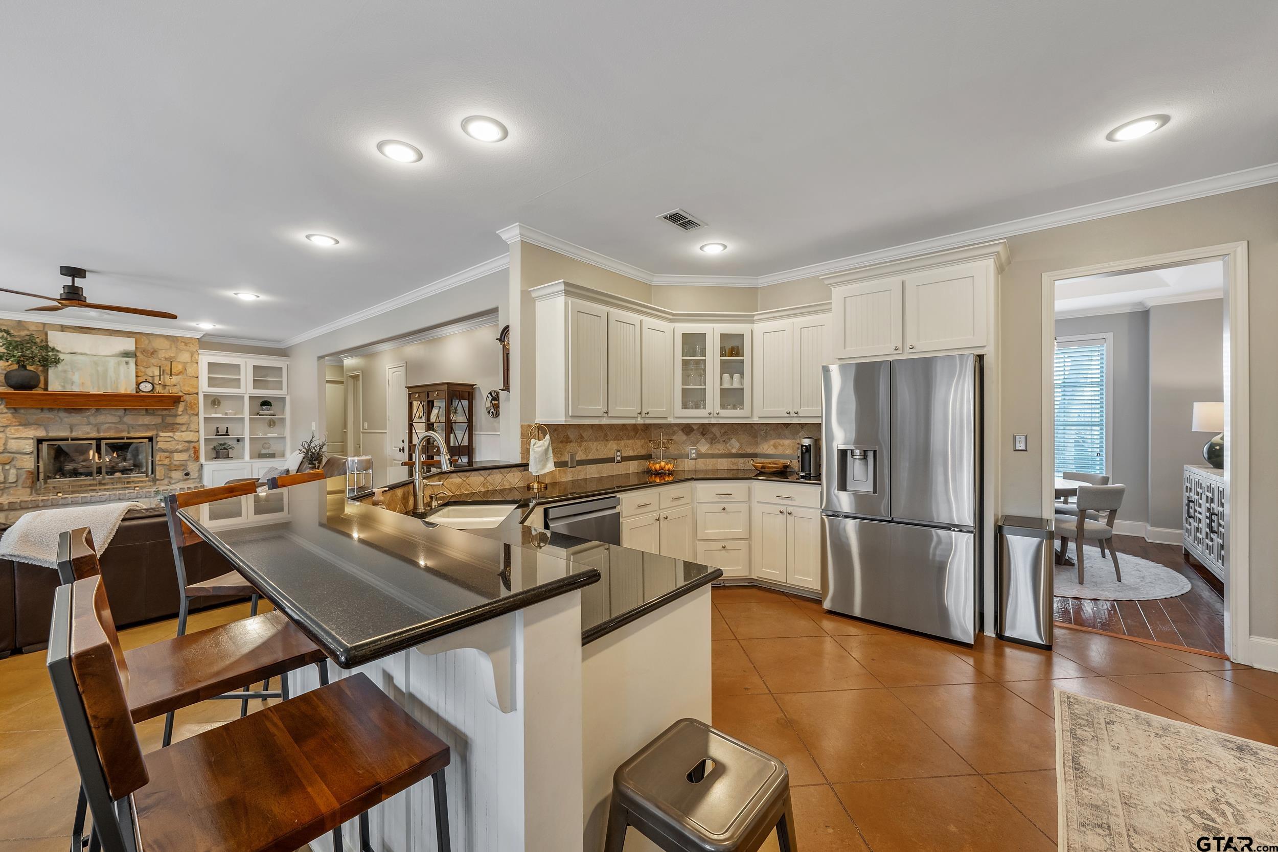 7752 Lamp Post Cove Tyler, TX 75703 - Photo 6 of 41 a kitchen with a table chairs refrigerator and cabinets