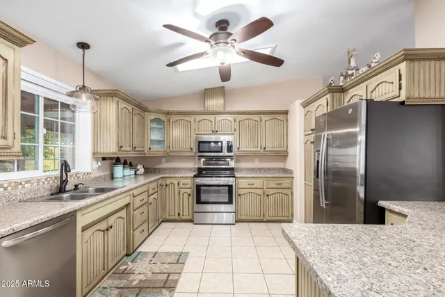 a kitchen with stainless steel appliances granite countertop a sink refrigerator and cabinets