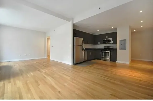 a view of a kitchen with a sink and a refrigerator