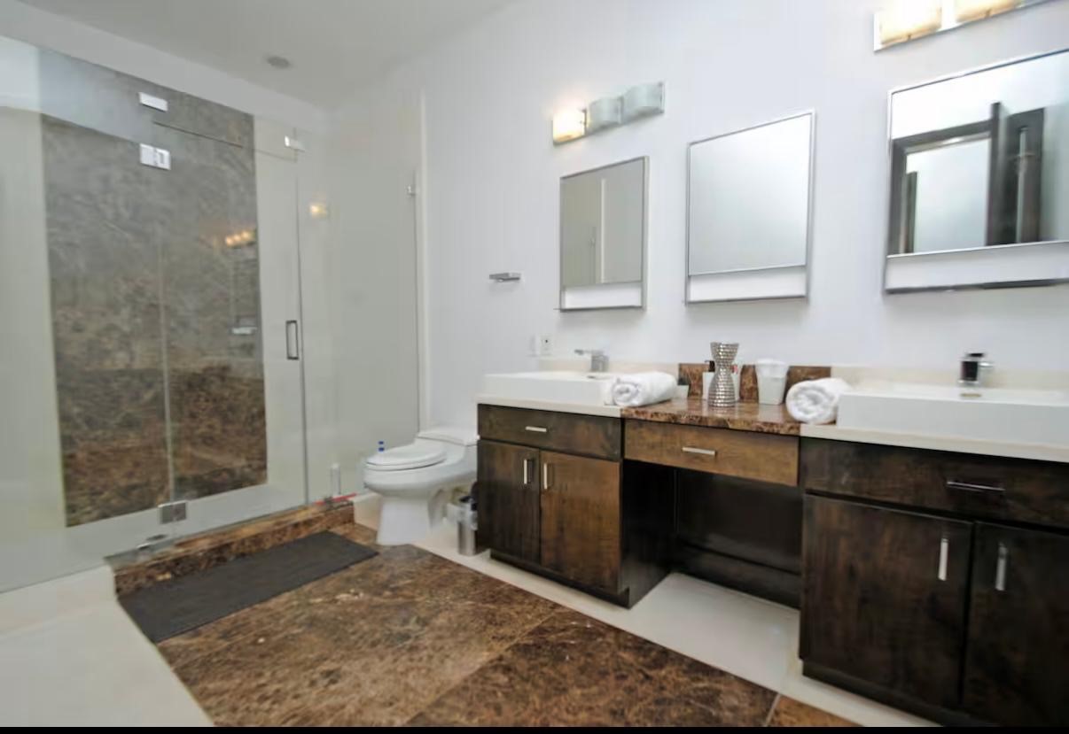 4118 Floyd Street, Unit A Houston, TX 77007 - Photo 11 of 25 a spacious bathroom with a sink a toilet a shower and a mirror