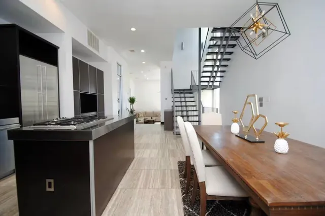 a kitchen with granite countertop a stove chairs and dining table