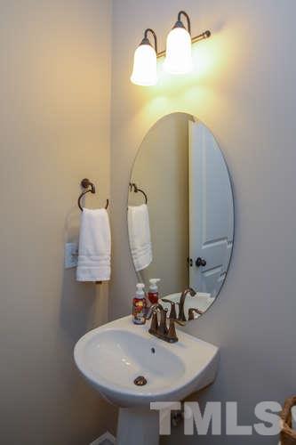 720 Wickham Ridge Road Apex, NC 27539 - Photo 5 of 21 The powder room is complete with pedestal sink. There are oil-rubbed bronze lighting and fixtures found throughout.