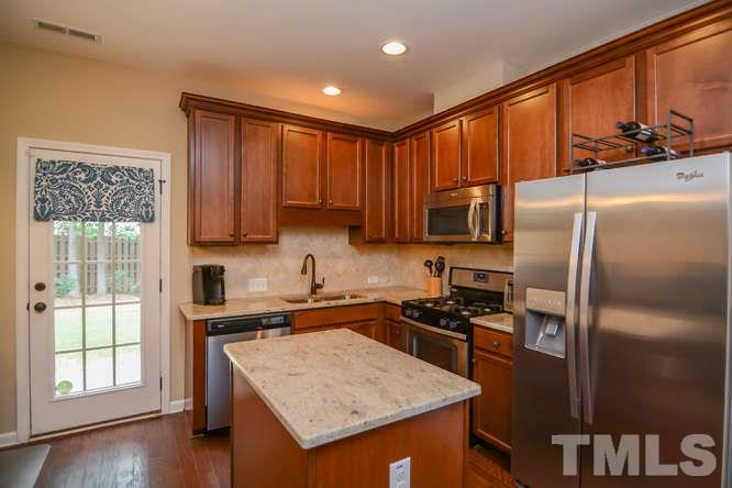 720 Wickham Ridge Road Apex, NC 27539 - Photo 6 of 21 This updated kitchen includes a gas range, maple cabinets, granite countertops, tile backsplash and stainless appliances.