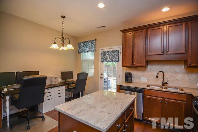 720 Wickham Ridge Road Apex, NC 27539 - Photo 7 of 21 The kitchen opens to the breakfast area. There is also access to the patio and backyard space.