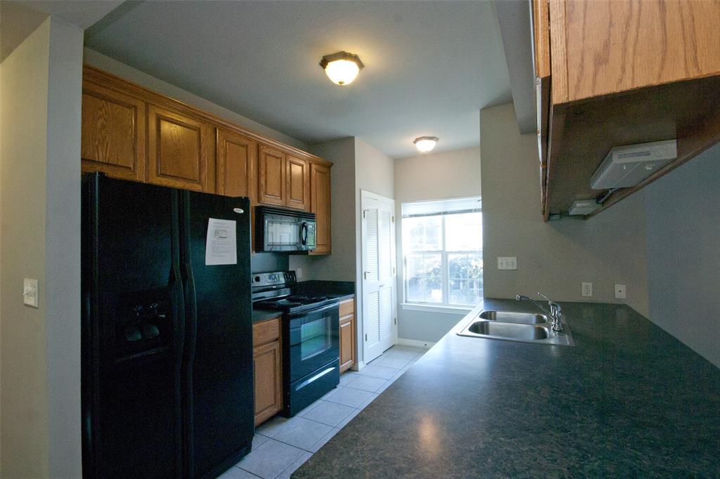 2410 Leon Street, Unit 103 Austin, TX 78705 - Photo 2 of 7 a kitchen with granite countertop a stove and a wooden floor