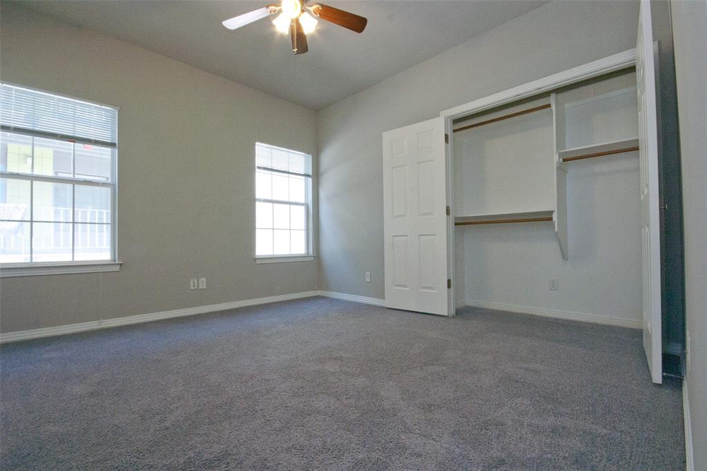 2410 Leon Street, Unit 103 Austin, TX 78705 - Photo 4 of 7 an empty room with a chandelier fan and windows