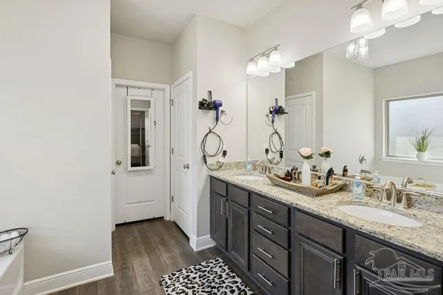a bathroom with a granite countertop sink a mirror and a shower
