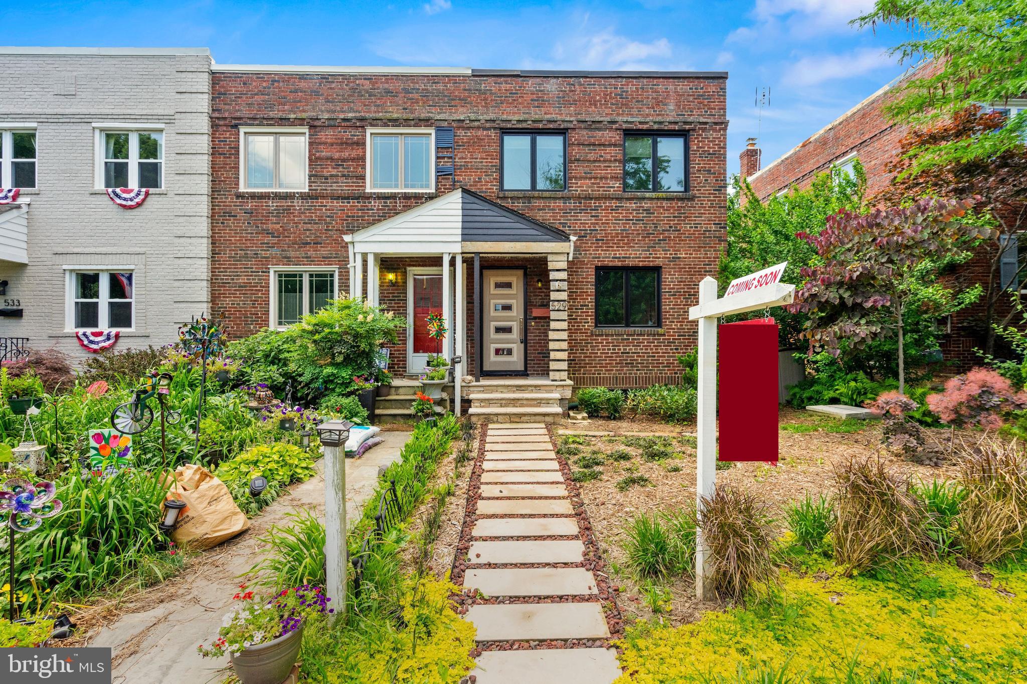 a front view of a house with a yard and flowers