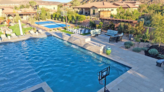 168 South Rancho Santa Fe Virgin, UT 84779 - Photo 48 of 58 Swimming pool with integrated water features, stone patio, adjacent outdoor lounge area, pickleball court, and manicured landscaping