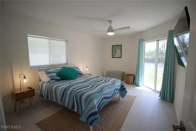 a bedroom with a bed lamp and a large window