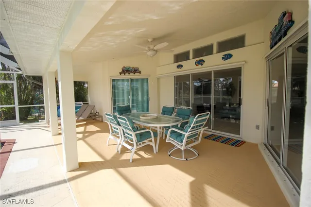a patio with table and chairs and potted plants