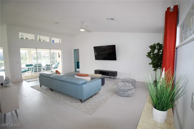 a living room with furniture a large window and a flat screen tv