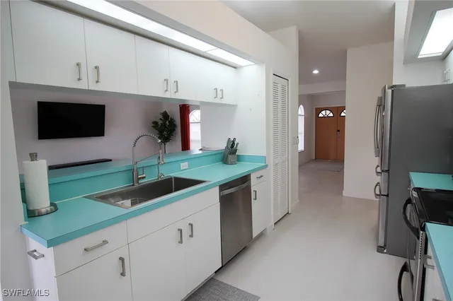 a kitchen with stainless steel appliances granite countertop a sink and a refrigerator