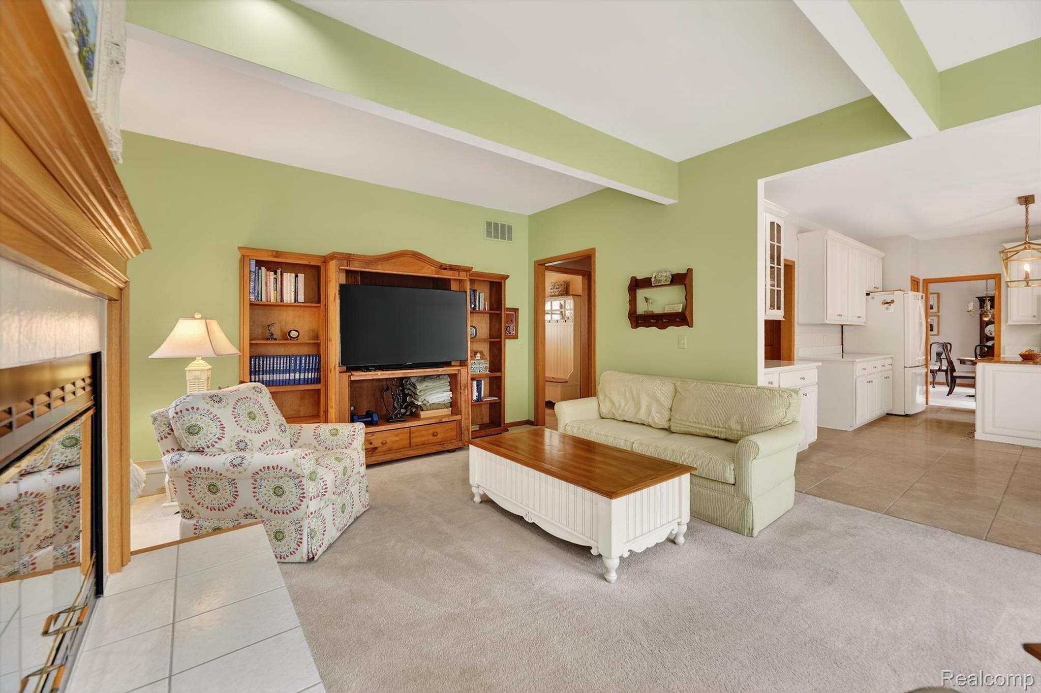 7798 Lee Road Brighton, MI 48116 - Photo 15 of 49 Living area featuring light tile patterned floors, light carpet, and beamed ceiling