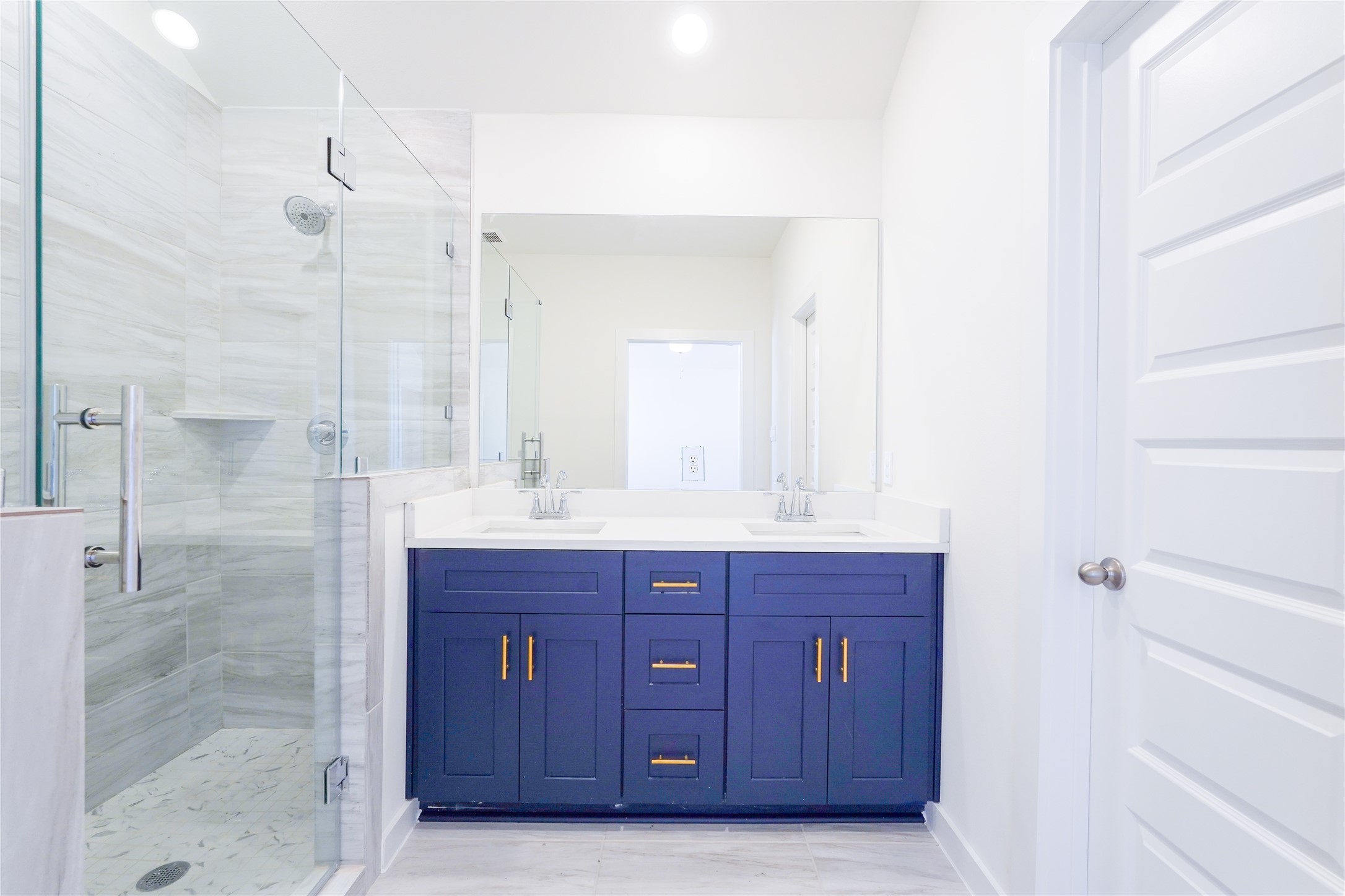 6618 Escondido Drive Rosharon, TX 77583 - Photo 18 of 31 This bathroom features a modern design with a glass-enclosed shower, marble-style tiles, a sleek double vanity with dark cabinetry, and stylish fixtures.