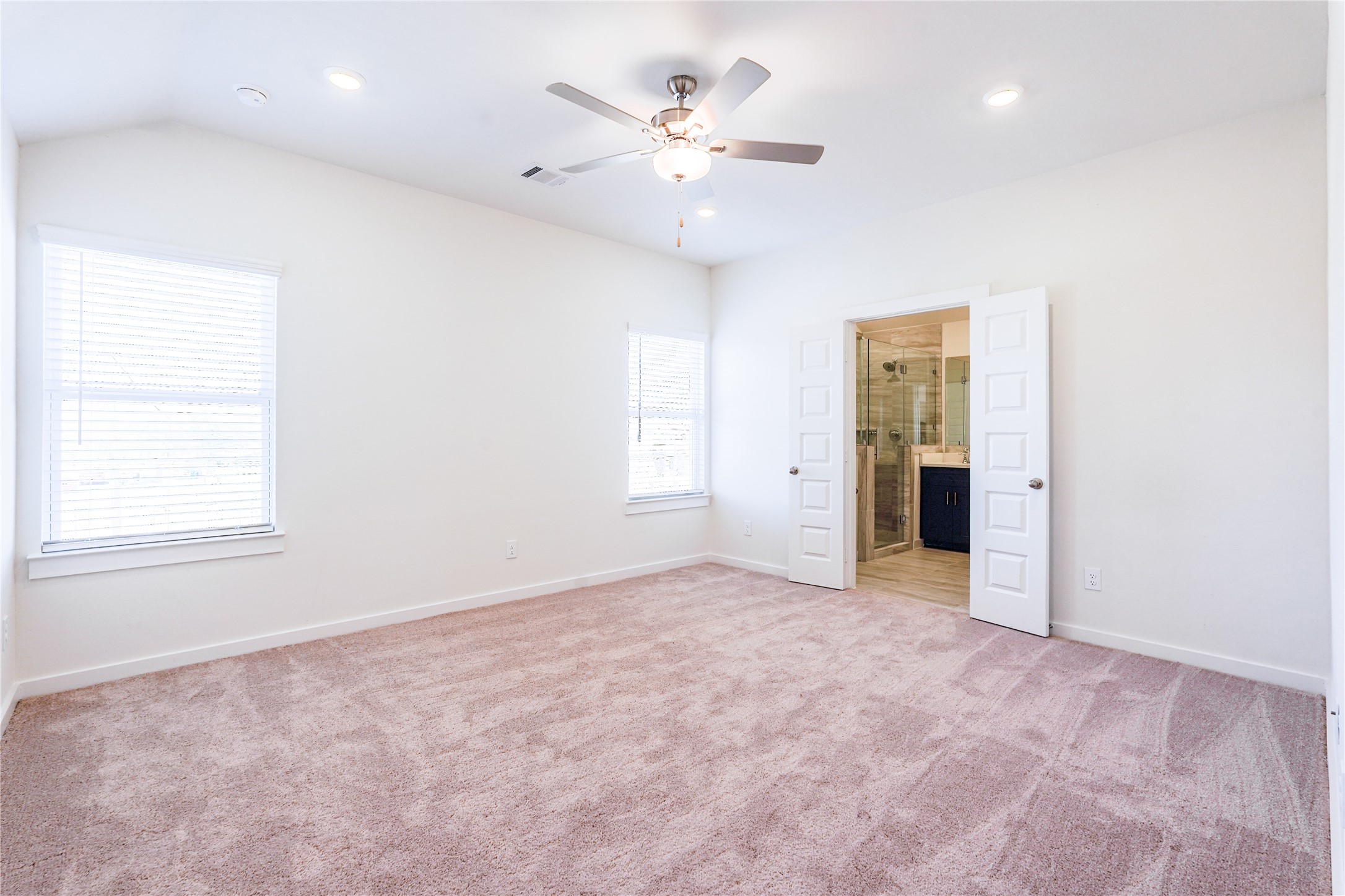 6618 Escondido Drive Rosharon, TX 77583 - Photo 23 of 31 This bathroom features a modern design with a large vanity and dual sinks, complemented by a sleek blue cabinet. The shower-bath combo is finished with elegant beige tiles, and there's ample natural light.