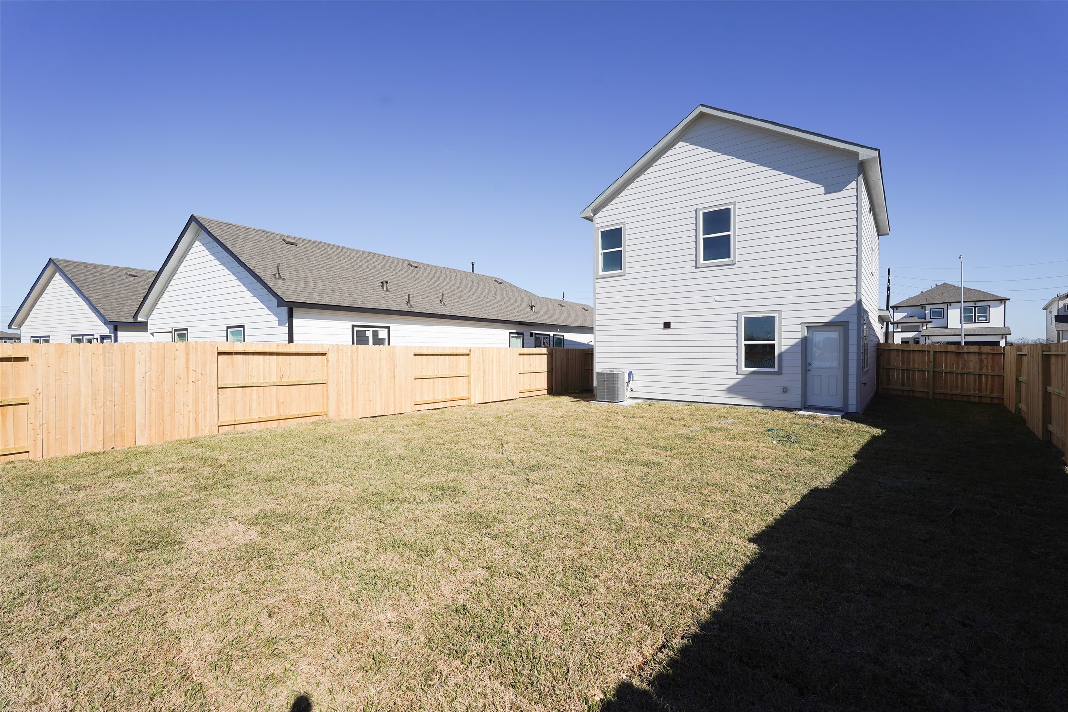 6618 Escondido Drive Rosharon, TX 77583 - Photo 25 of 31 Spacious fenced backyard with a well-maintained lawn, ideal for outdoor activities. The house features a modern exterior with two stories, offering plenty of natural light.