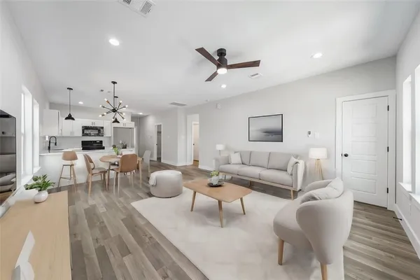 a living room with furniture and a wooden floor