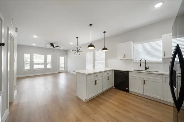 an empty room with wooden floor and ceiling fan