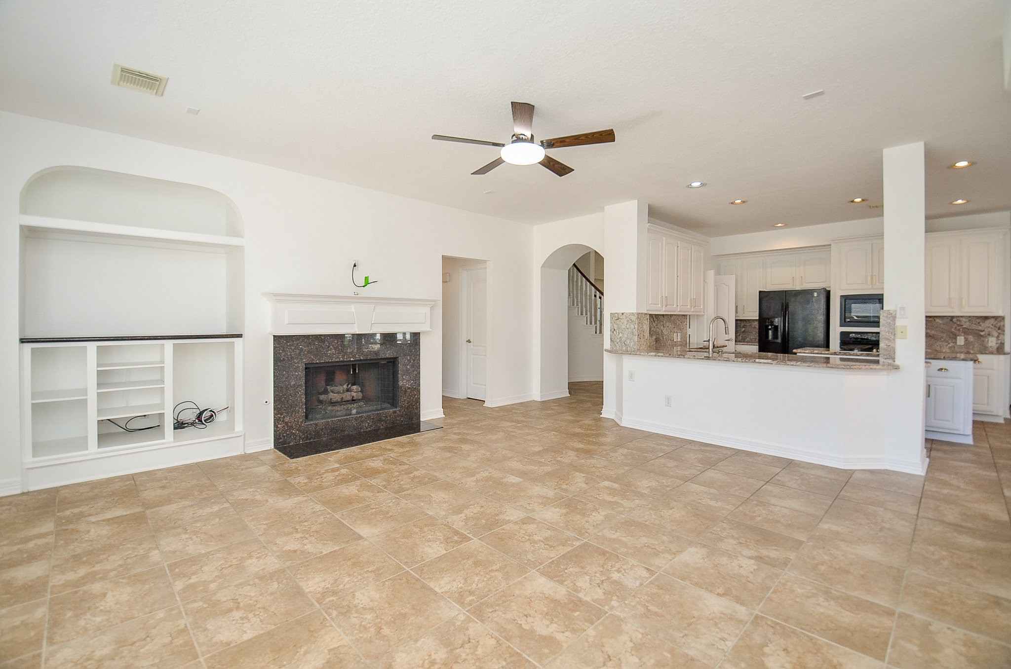 5615 Bent Arbor Lane Katy, TX 77450 - Photo 11 of 42 Built in entertainment niche in the corner houses your components so that you can view your TV from above the gas log fireplace. Surround sound wiring is in the ceiling for any speakers you might want to install (with landlord permission of course). Hallway next to the fireplace leads to the master bedroom suite with the powder room seen on the right.